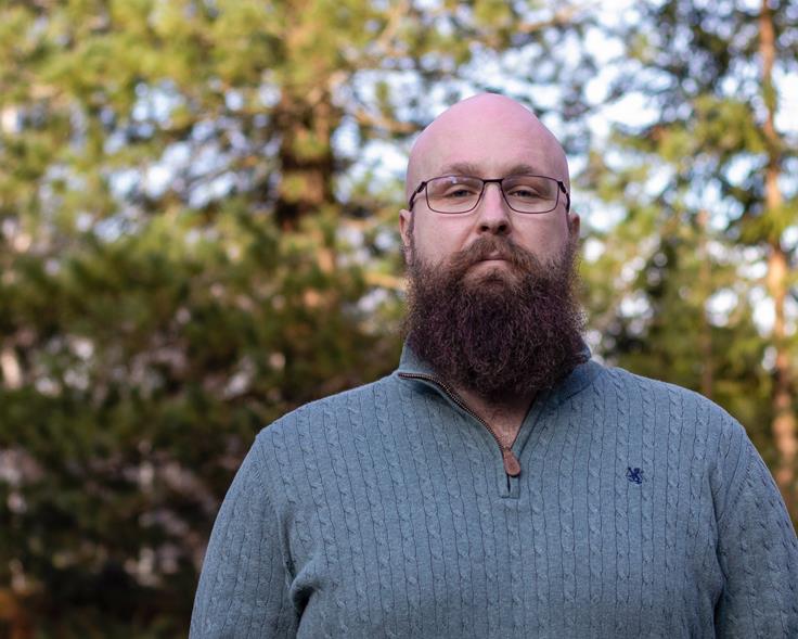 Portrett av Kristian forran en skog.