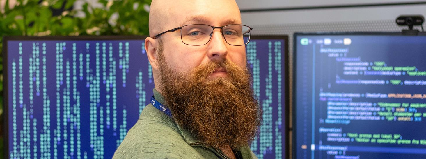 Portrett av Mann forran skog.