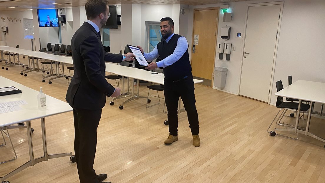 Statsråd Nikolai Astrup gir diplom til Osman Mohammad Ibrahim
