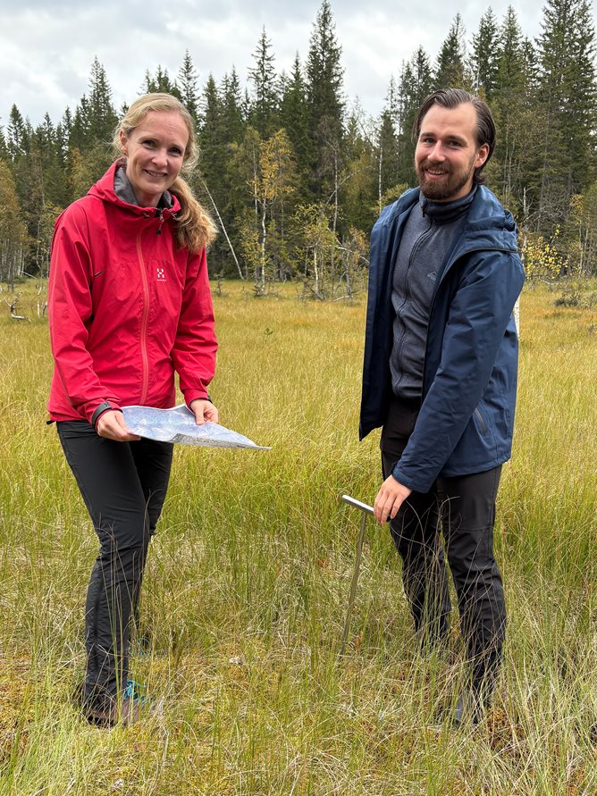 Kvinnelig og mannlig ansatt i Kartverket i ei myr.