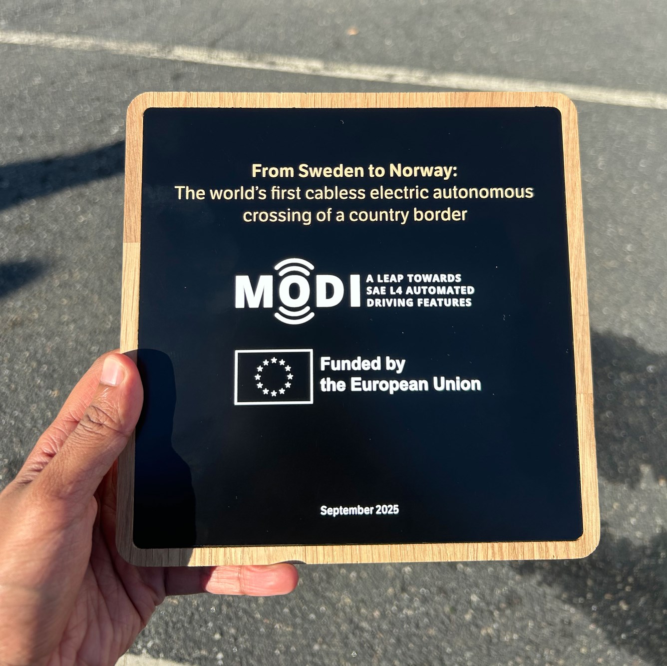 En h&aring;nd som holder en plankett som dokumenterer f&oslash;rste grensekryssing med f&oslash;rerl&oslash;s trailer