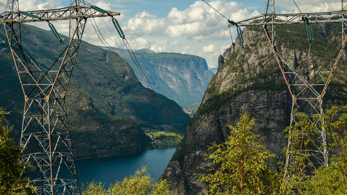 Høyspentmaster gjennom skoglandskap med åser