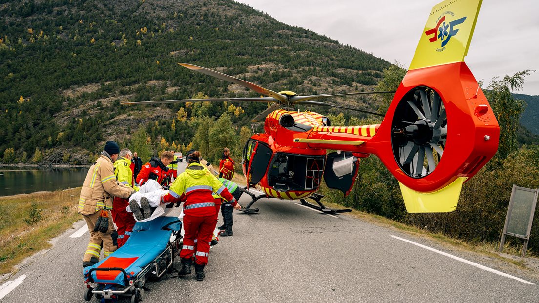 Mannskap bærer båre inn i ventende ambulansehelikopter