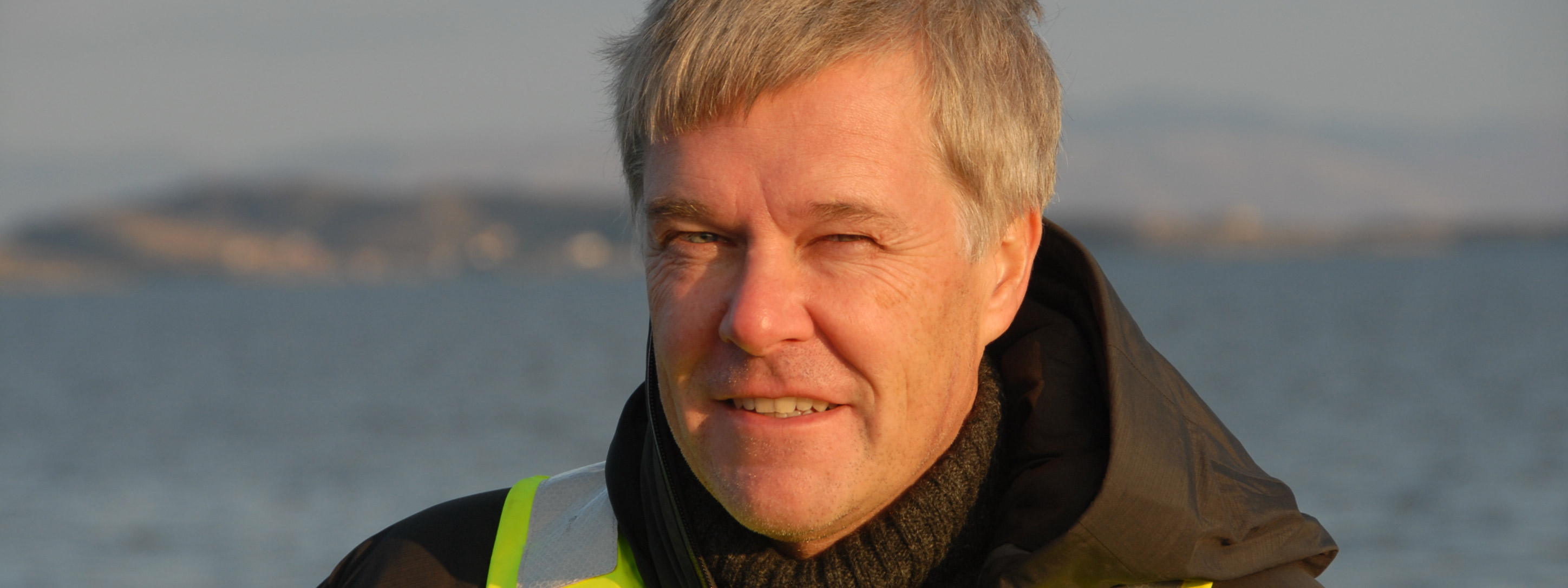 Portrettfoto av Jon Arne Grøttum med rød sommersol i ansiktet. Foto: Sjømat Norge