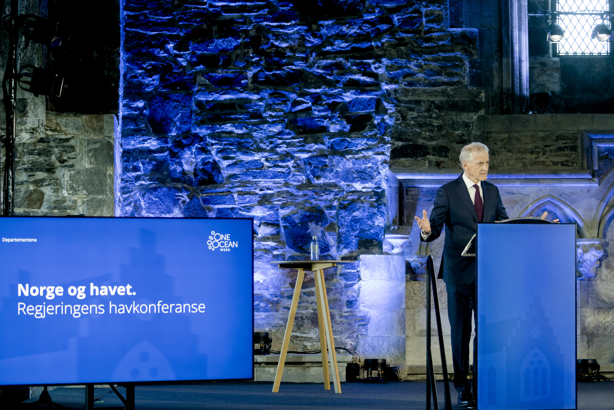 Stasminister Jonas Gahr Støre står ved en blå talerstol og snakker på regjeringens havkonferansen i 2023. Foto: Paul S. Amundsen/Klima- og miljødepartementet