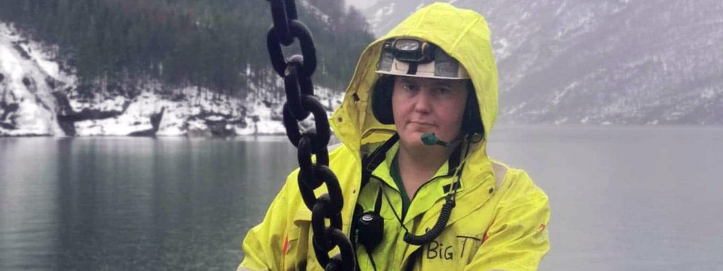 Truls Bjørkestøl står ute i snøvær og styrer en kjetting med krok. Foto: Privat