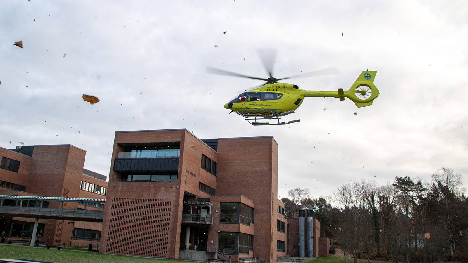Luftambulanse lander ved en administrasjonsbygning. Foto:Magnus Nødland Skogedal