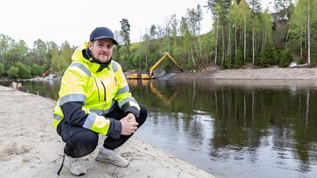 Kommunal geolog foran Randselva og gravemaskiner i Hønefoss sentrum. Foto: Åsgeir Størdal/ Kartverket
