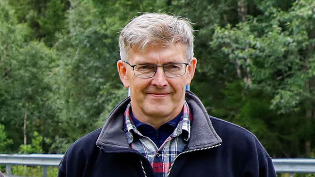 Anders Østeraas står i skogen på grensen mellom Norge og Sverige.