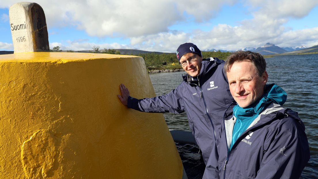 Anders Østeraas og Tor Erik Bakke står ved Treriksrøysa på 69 grader nord. Foto.