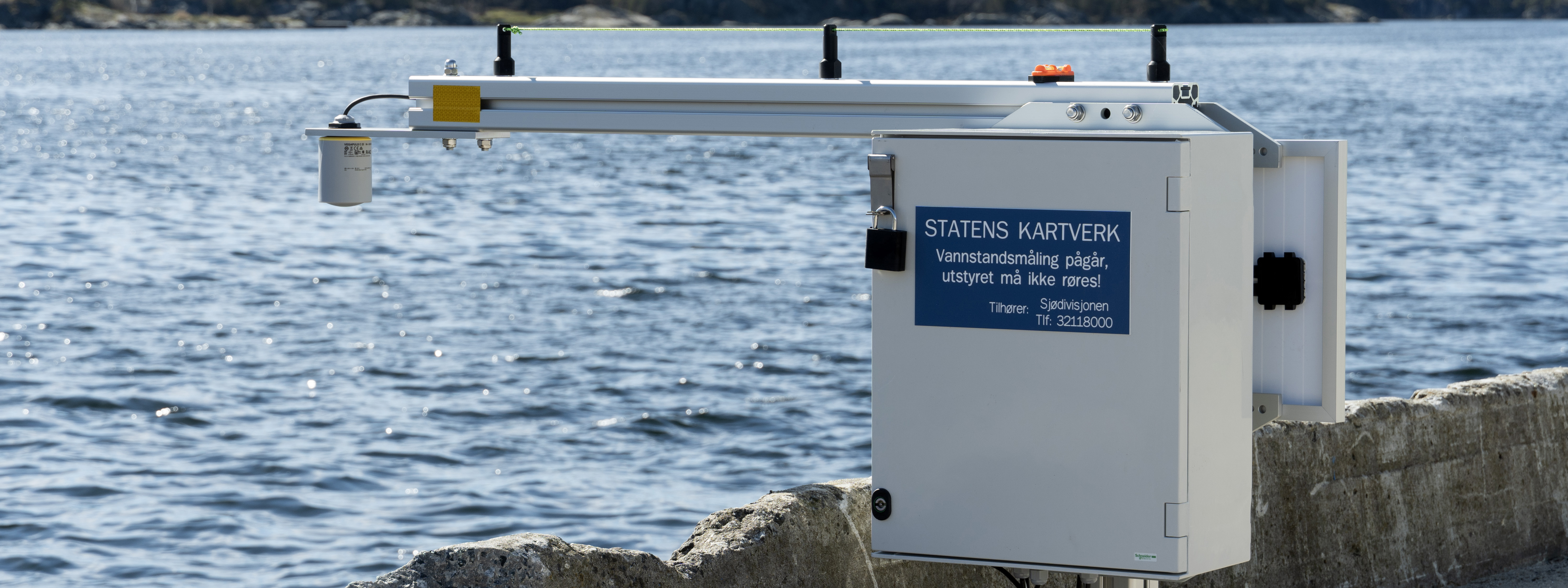 Midlertidig vannstandsmåler, radarmåler, plassert på ei kai med hav i bakgrunnen.