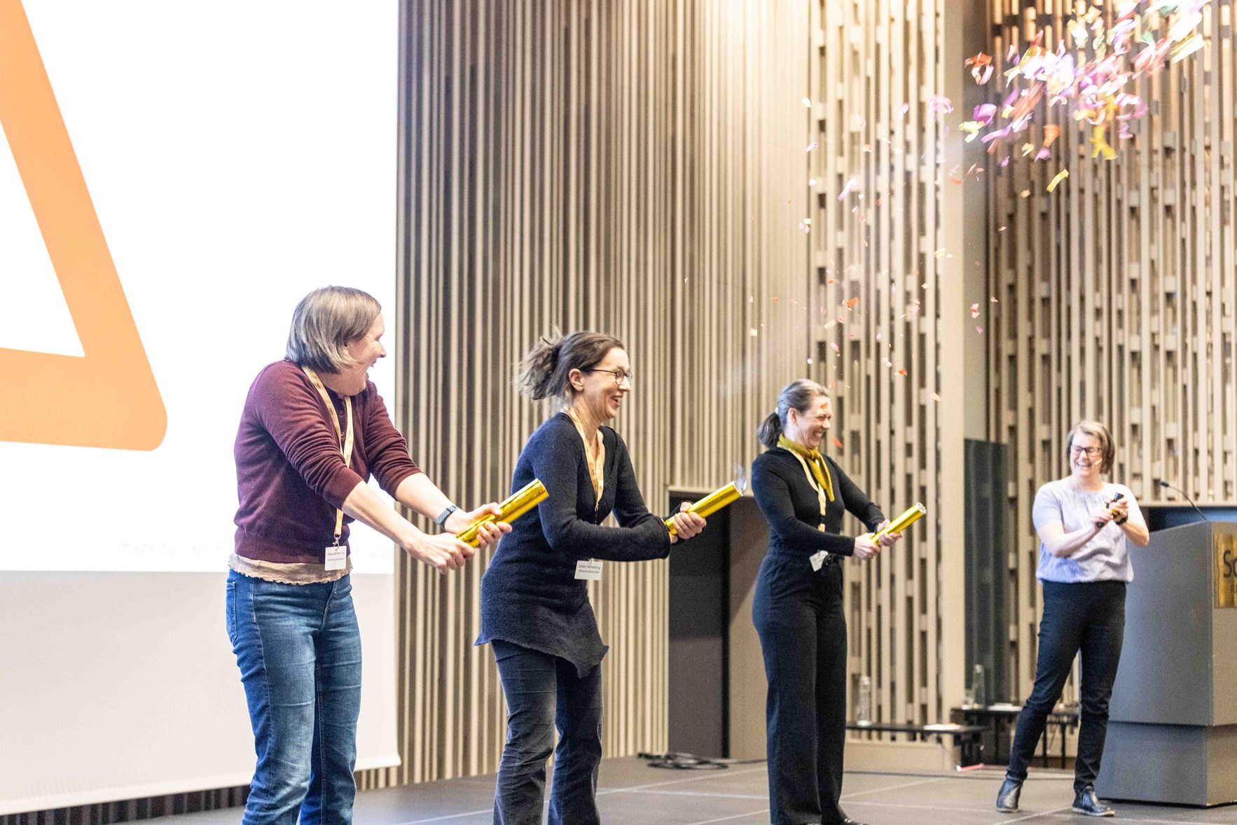 Fire damer p&aring; scenen fyrer av konfetti for &aring; feire ny testversjon av Nasjonalt grunnkart for arealregnskap