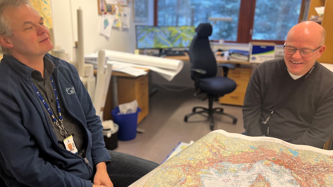 To ansatte ved Kartverket med et kart mellom seg
